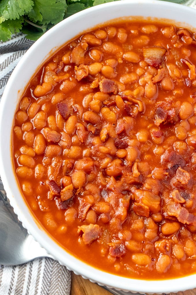 an overhead image of a large white bowl filled with baked beans