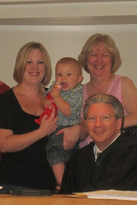 A group of people posing for the camera with a baby boy