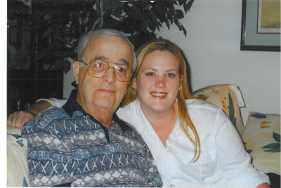 A dad and his adult daughter sitting together on a yellow sofa