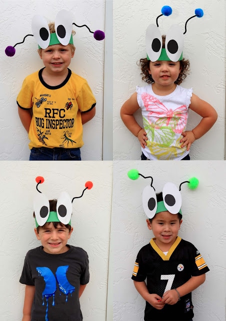 A group of children posing for the camera with bug hats