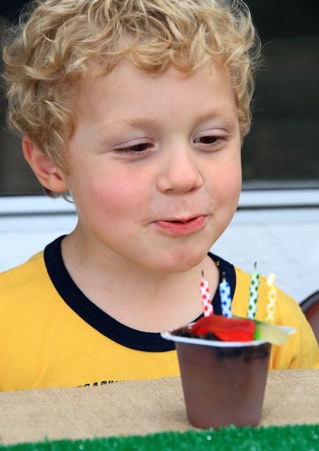 A little boy blowing out birthday candles