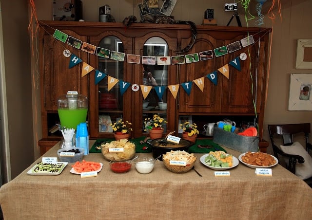 A kitchen with food, birthday signs, punch, and decor.