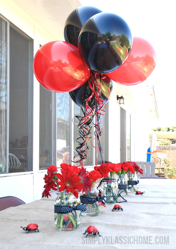 Vases of flowers and balloons on a table