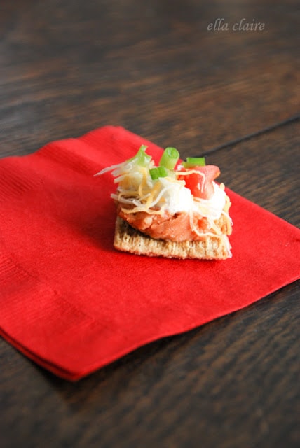 A cracker with dip on top on a red napkin