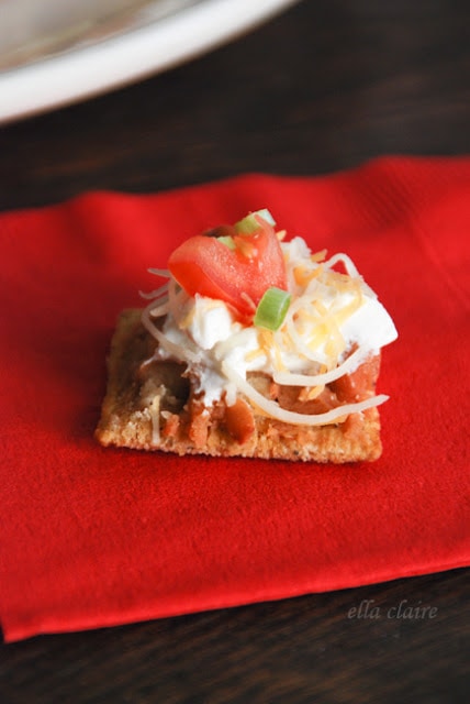 A cracker with dip on a red napkin