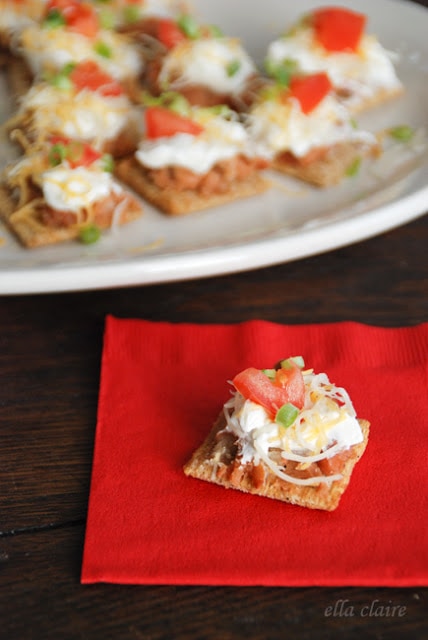 A cracker with dip on top on a red napkin