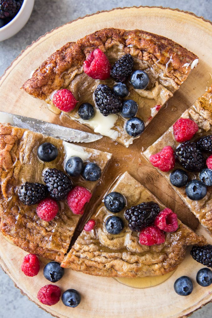 Baked pancake sliced into triangles with berries on top. 