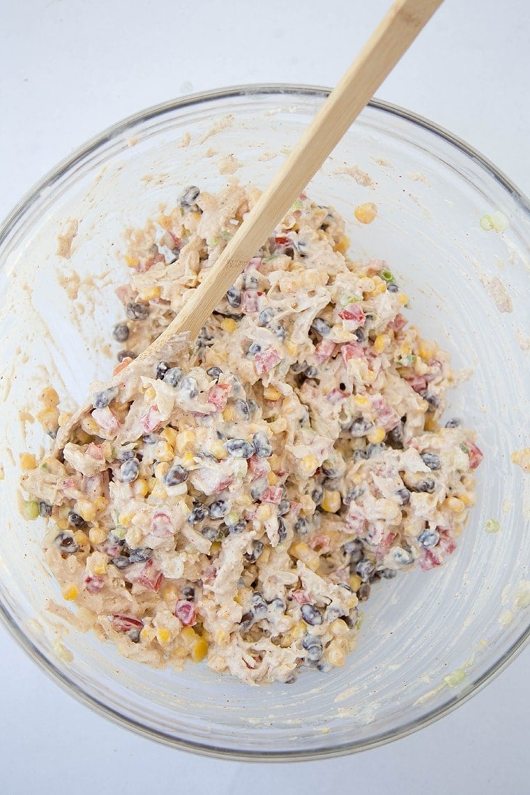 Skinny Southwest Chicken Salad mixed together in a bowl with a wooden spoon