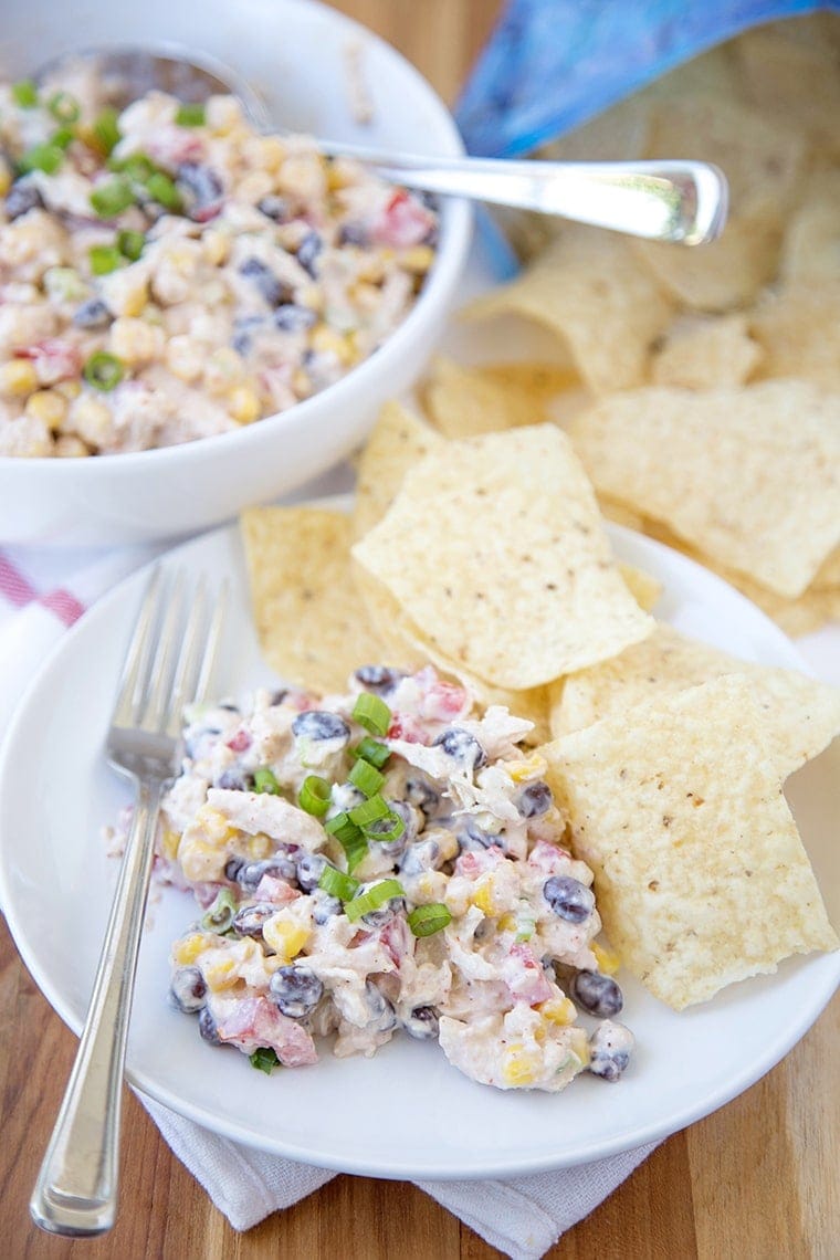 salada de frango Skinny Southwest em um prato servido como um mergulho com batatas fritas de tortilha.