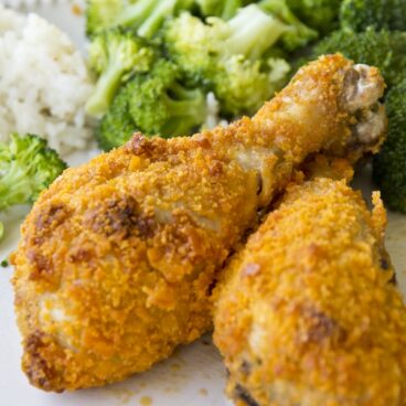A plate of chicken drumsticks with broccoli