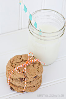 Stack of cookies next to a glass of milk on a table