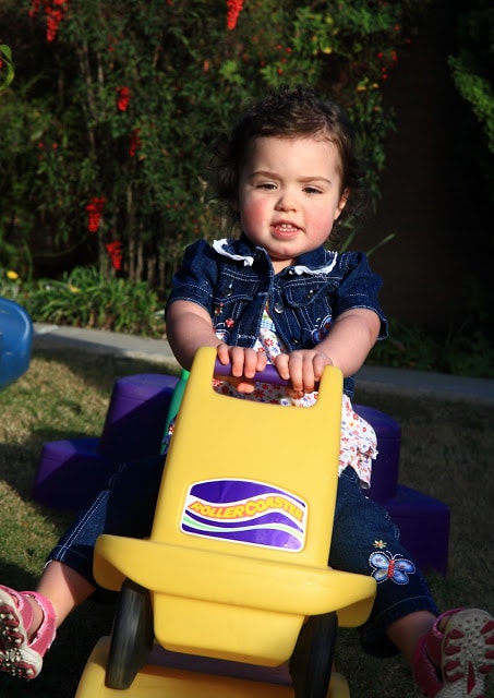 A little girl sitting on a toy