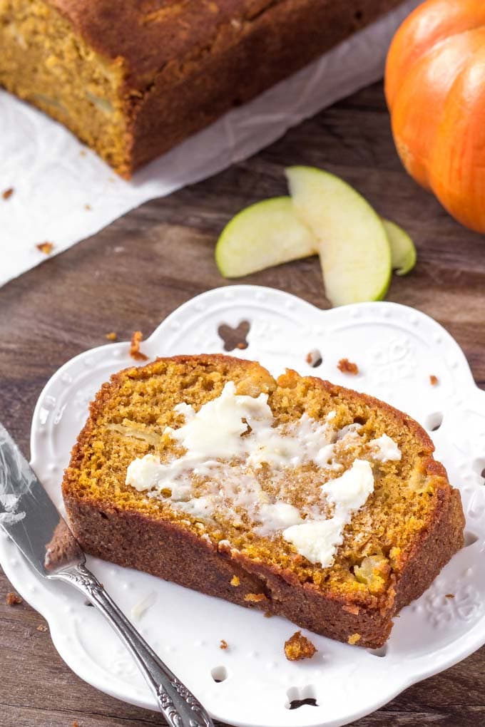 A slice of Pumpkin Bread with Apples spread with butter.