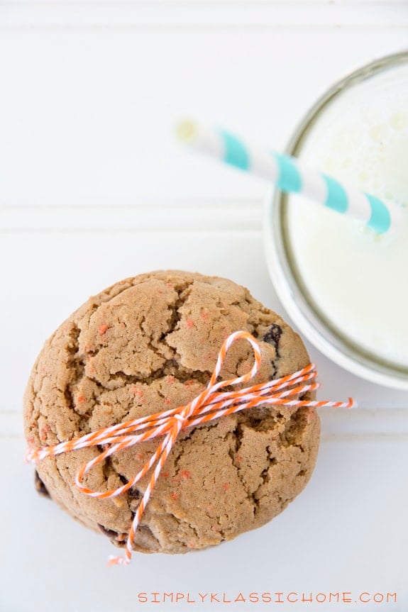 Stack of cookies on a table with a cup of milk