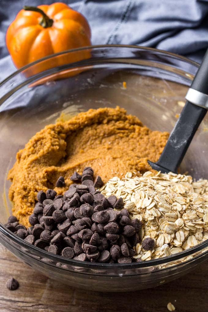 Ingredients to make These Oatmeal Pumpkin Chocolate Chip Cookies in a glass bowl.