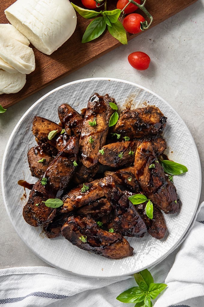 a white plate with balsamic marinated chicken