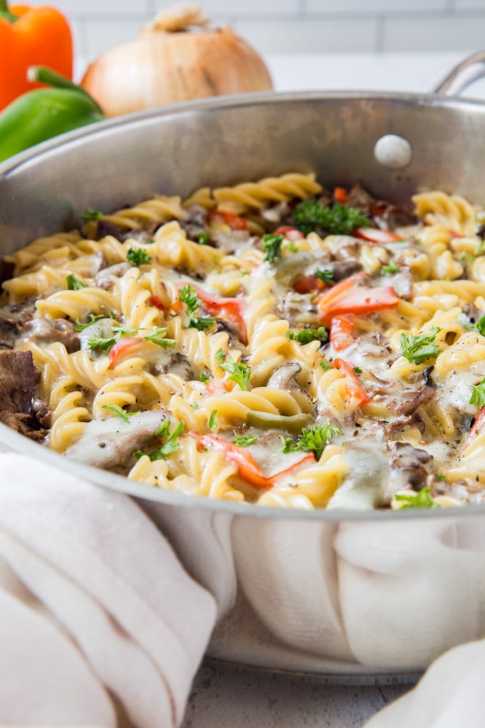 A stainless steel skillet with philly cheesesteak pasta