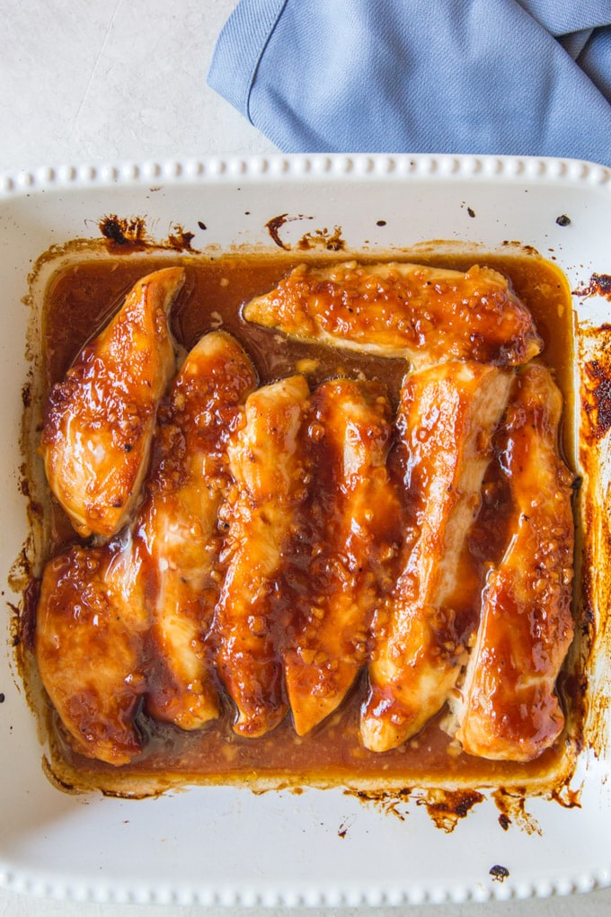 Chicken tenders in a white baking dish.