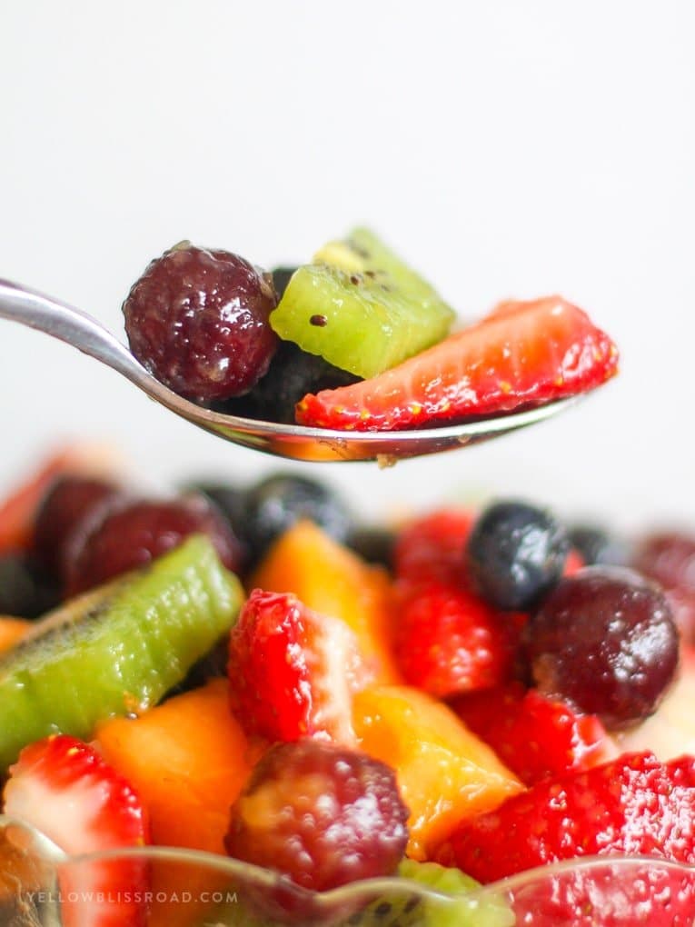 fruit salad recipe with vanilla pudding - a grape and strawberry on a spoon