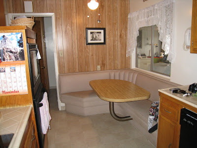 A kitchen with a bench seat and table