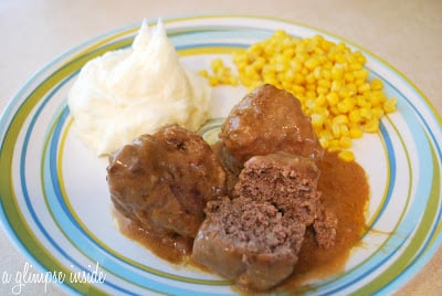 A plate of meatballs, mashed potatoes, and corn