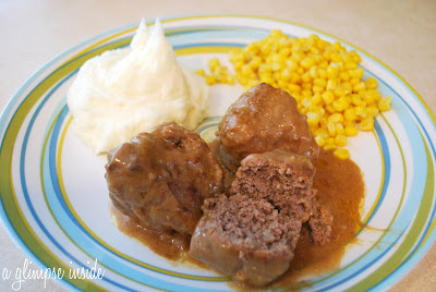 A plate of meatballs, mashed potatoes, and corn