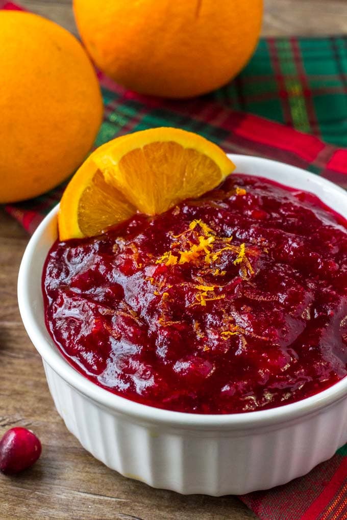 Homemade Cranberry Orange Sauce in a white dish with orange slices.