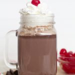 Hot chocolate in a glass mug with whipped cream on top