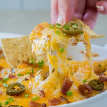 Tortilla chips and cheesy dip with bacon and jalapenos