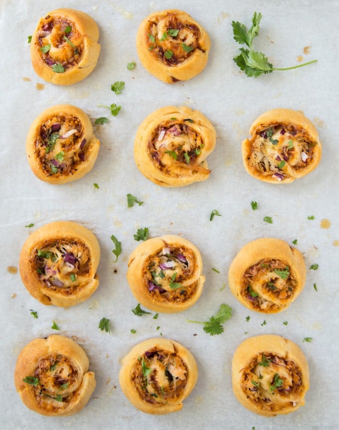 BBQ Chicken Pizza Pinwheels arranged on a baking sheet lined with parchment paper.