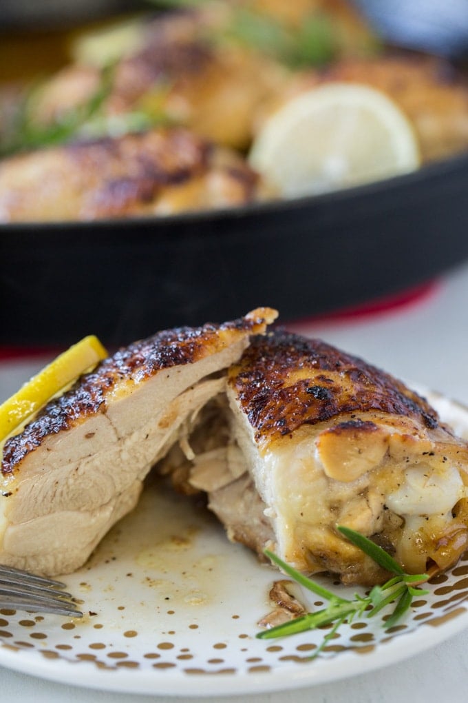 A roasted chicken thigh cut in half to chow the meat inside.