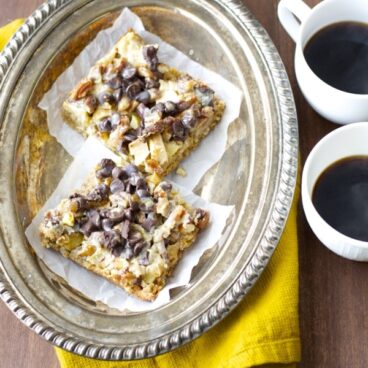 A plate of bars and two cups of coffee