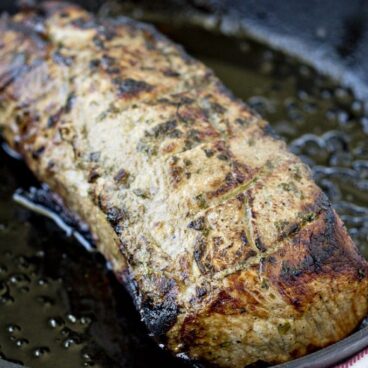 Pork loin roasting in a pan