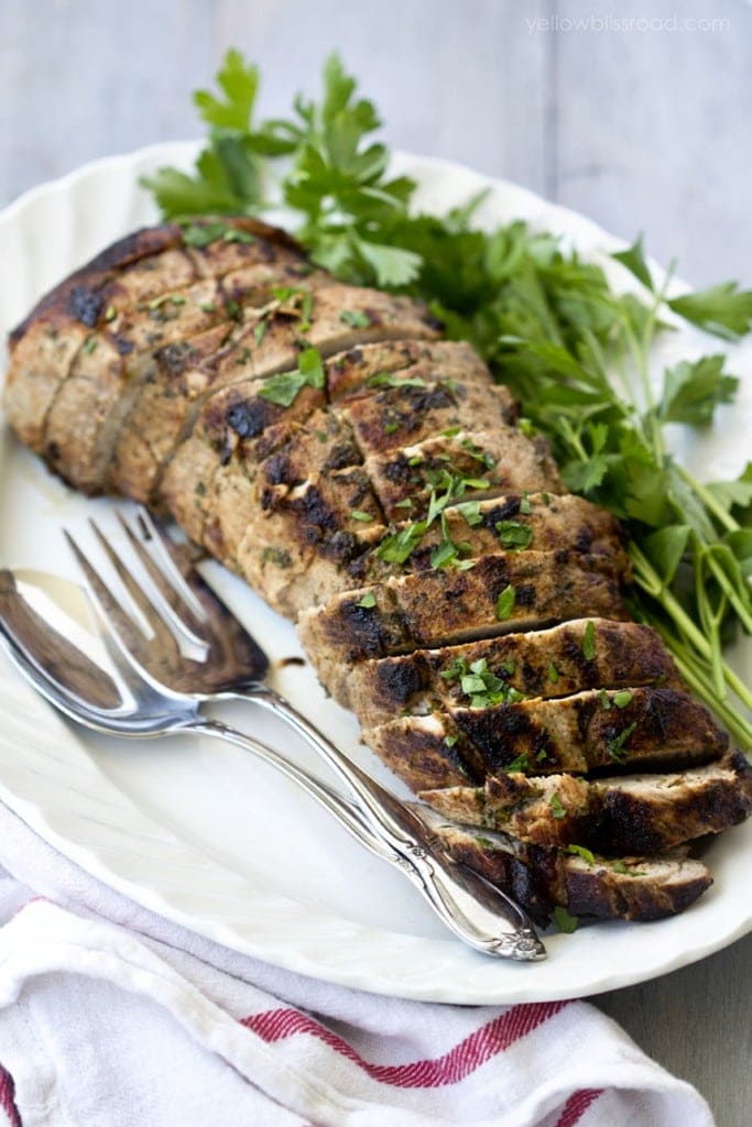 Marinated and Pan Roasted Pork  sliced on a platter with parsley