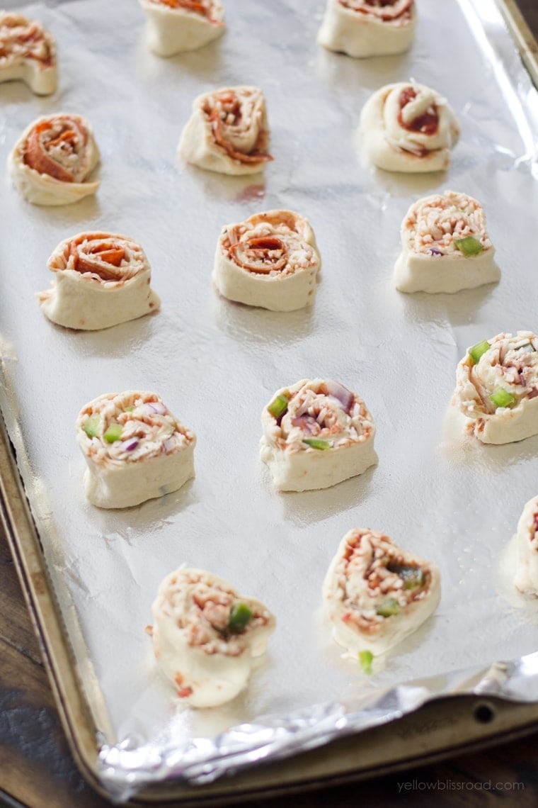 Pizza roll ups, sliced and placed on a baking sheet. 