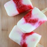 Strawberry Vanilla popsicles on a wooden table