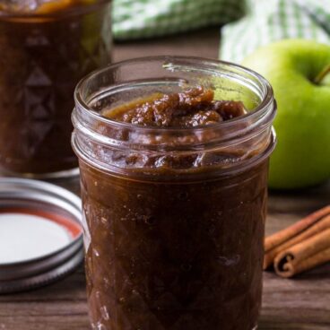 A jar filled with apple butter on a table