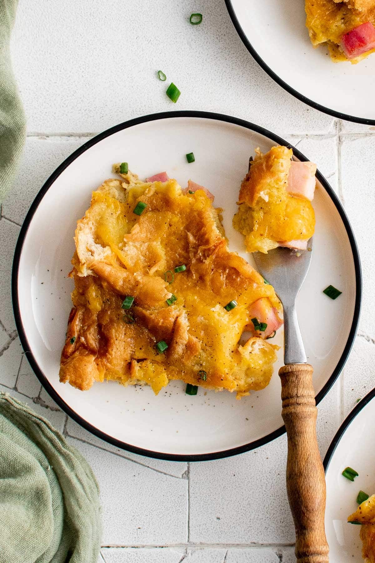 Breakfast casserole on a white plate with a fork.