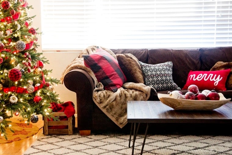 Chrismtas tree with buffalo check pillows on Brown sofa