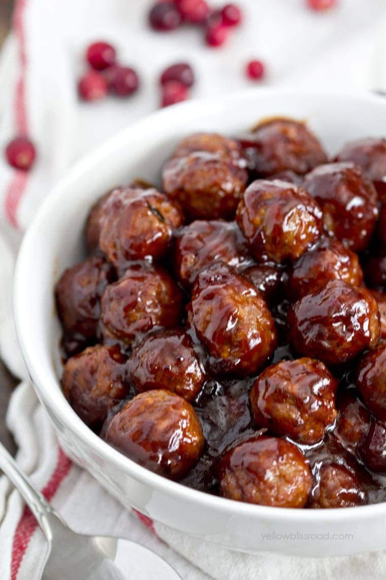Cranberry Barbecue Meatballs in a white bowl, cranberries, white and red napkin