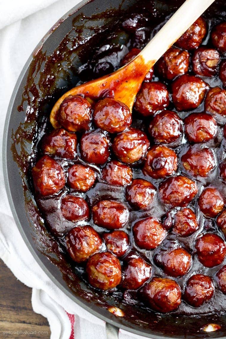 Cranberry Barbecue Meatballs in a skillet, wooden spoon