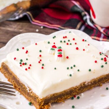 A close up of gingerbread bars with frosting and sprinkles