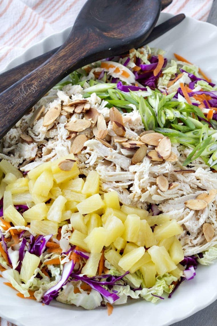 Tropical Chicken Slaw with Creamy Pineapple Vinegairette, Toasted Almonds & Sesame Seeds on a white platter