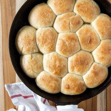 Cast iron pan filled with baked dinner rolls