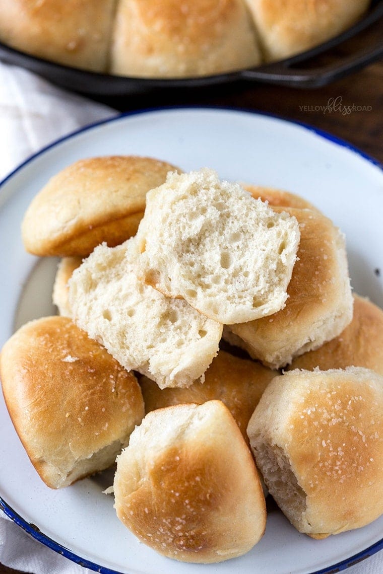 One Hour Dinner Rolls on a plate with one roll split in half.