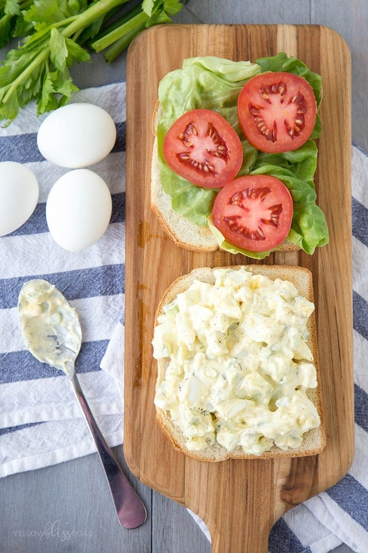 egg salad sandwich open faced with lettuce and tomato