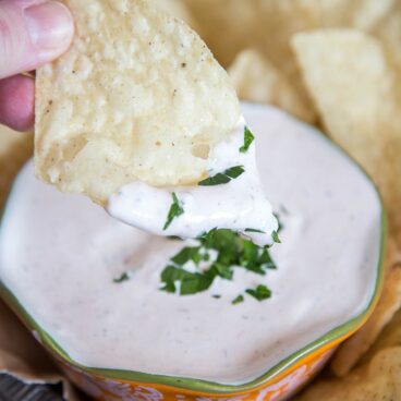 A chip dipped into a yogurt dip