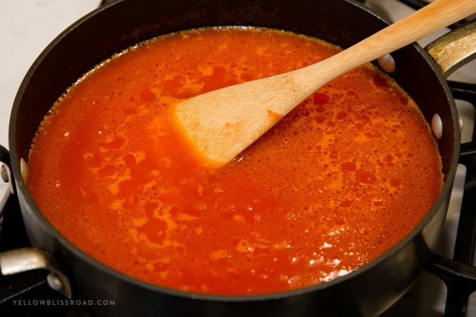 tomato sauce in a skillet with a wooden spoon