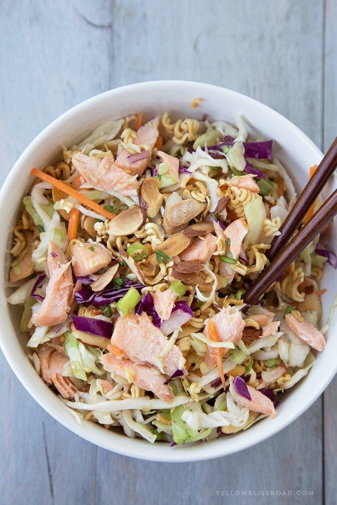 A serving sized bowl of ramen noodle salad with salmon