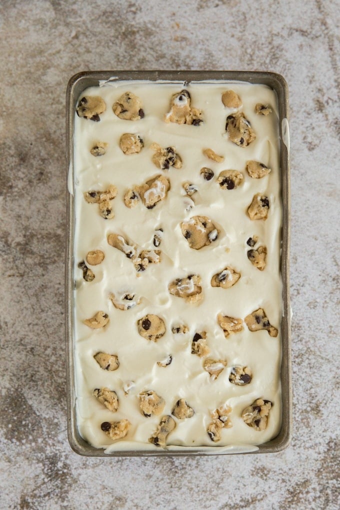 A pan of cookie dough ice cream, no churn, with chocolate chips, on a gray and white background.